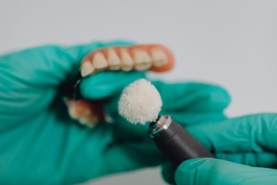 custom dentures being polished by a dental professional